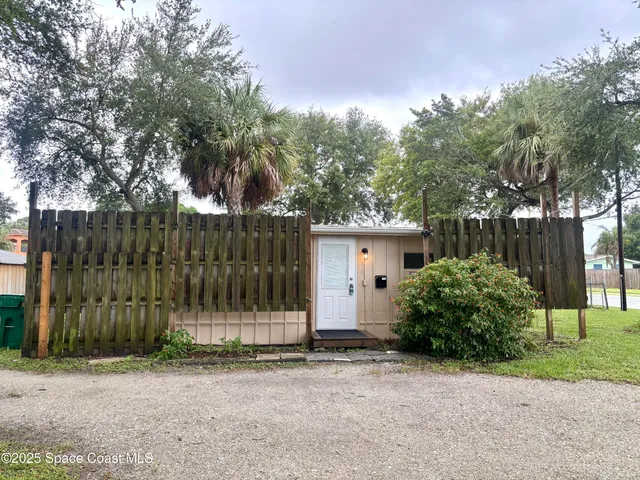 a front view of a house with a garden and plants