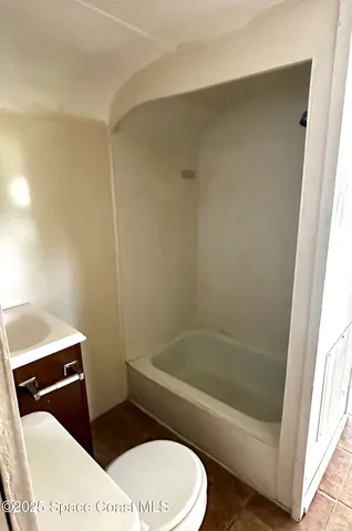 a bathroom with a toilet and a bath tub