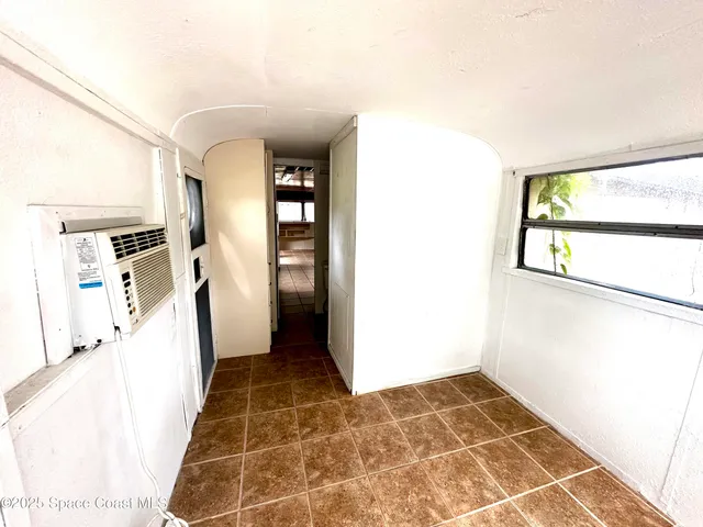 a view of a hallway with wooden floor and furniture