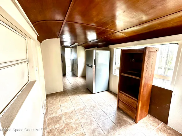 a view of a hallway with wooden floor and a glass door