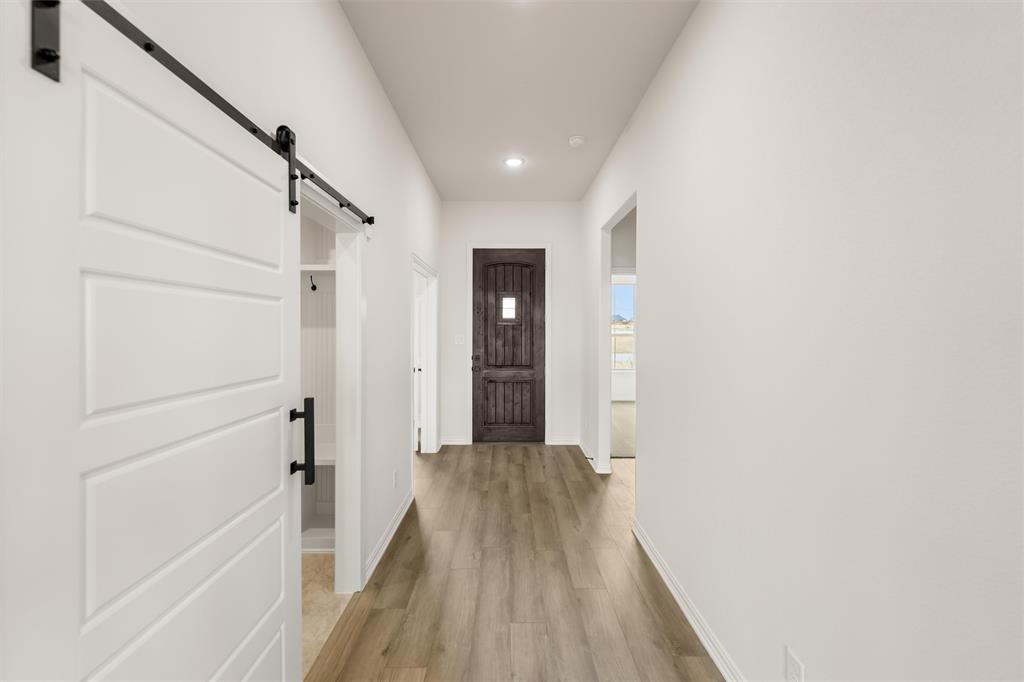 125 Snowy Owl Trail Rhome, TX 76078 - Photo 9 of 28 Entryway featuring a barn door, wood finished floors, and recessed lighting