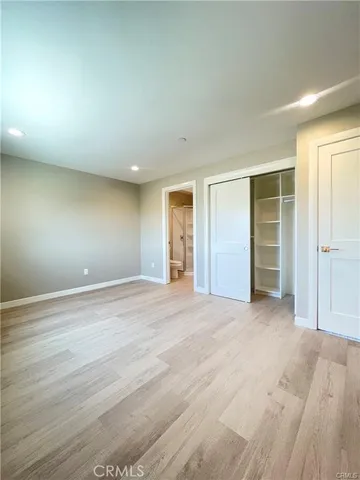 a view of an empty room with closet and a window