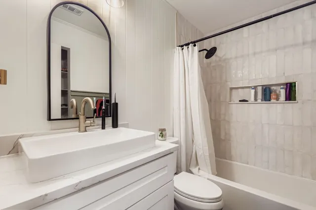 a bathroom with a sink a toilet and a mirror