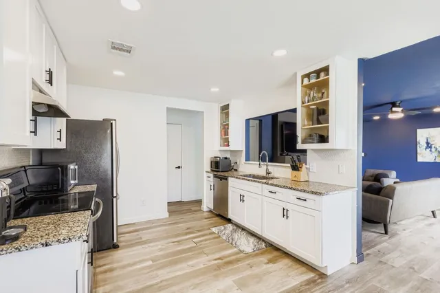 a large kitchen with a stove a sink dishwasher a refrigerator and a stove