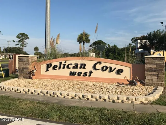 a view of sign board with buildings in background