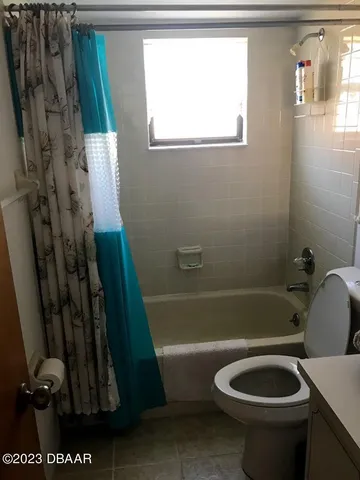 a bathroom with a sink a toilet a tub and shower