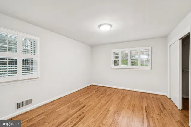 a view of a room with wooden floor and windows