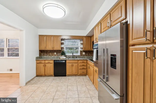 a kitchen with stainless steel appliances granite countertop a refrigerator a stove and a sink