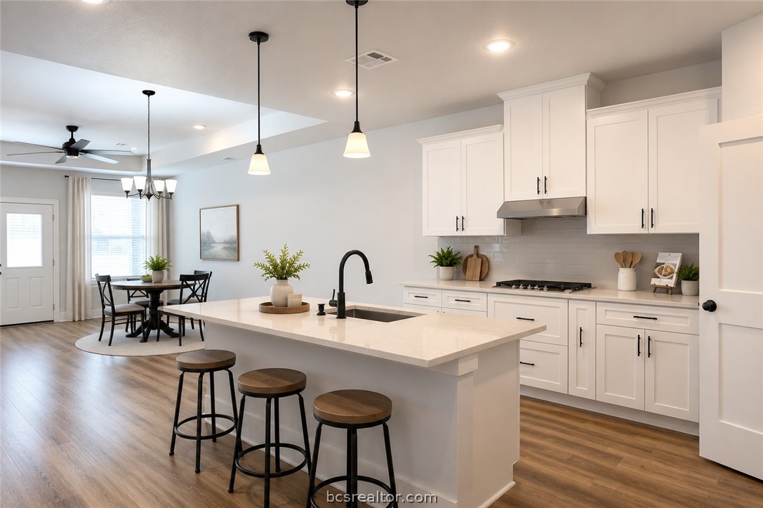 2012 Reagan Court Bryan, TX 77802 - Photo 5 of 19 a kitchen with a dining table chairs sink and cabinets