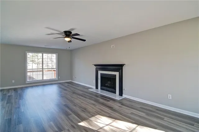 a view of an empty room with window and wooden floor