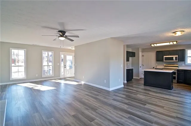 a large kitchen with a large counter top space appliances and cabinets
