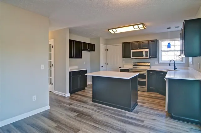a kitchen with stainless steel appliances a stove top oven and sink