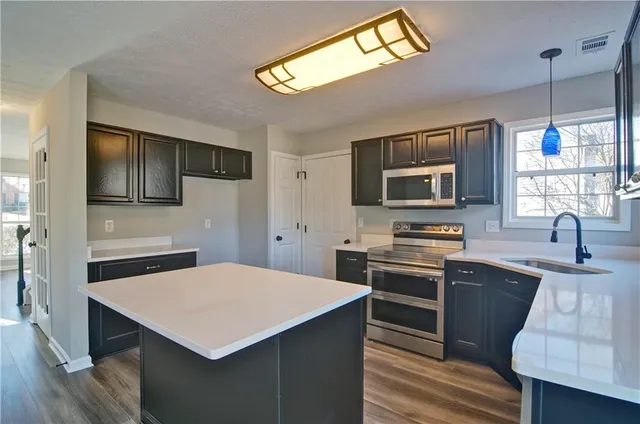 a kitchen with a sink stove and cabinets