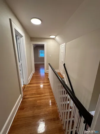 a view of a hallway with wooden floor and stairs