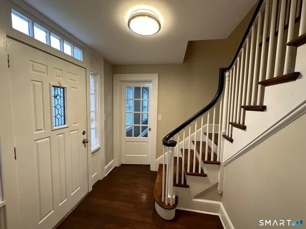 a view of entryway with wooden floor and stairs