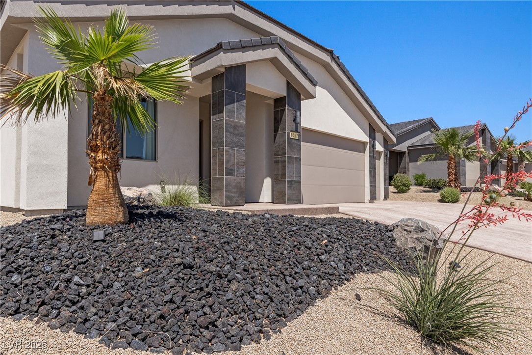 1357 Manassas Ridge Mesquite, NV 89027 - Photo 59 of 72 View of side of home with stucco siding, driveway, and a garage