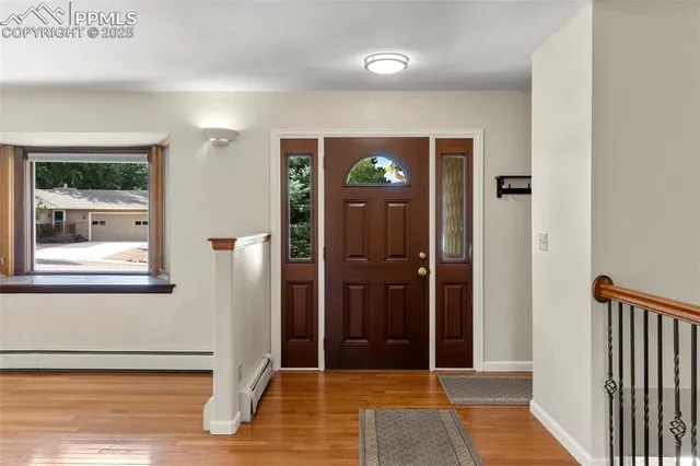 a view of a hallway with wooden floor and a living room