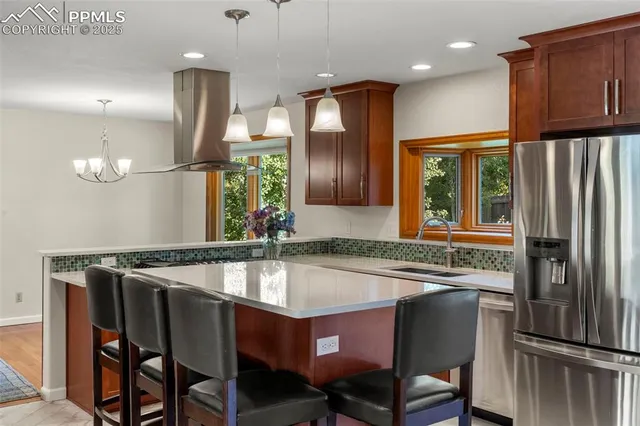 a kitchen with stainless steel appliances granite countertop a sink refrigerator and cabinets