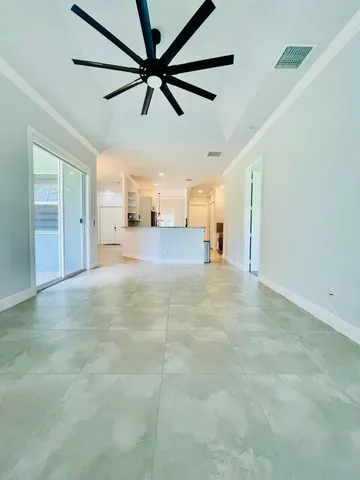 an empty room with a ceiling fan and a window