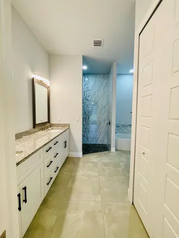 a spacious bathroom with a granite countertop sink mirror and
