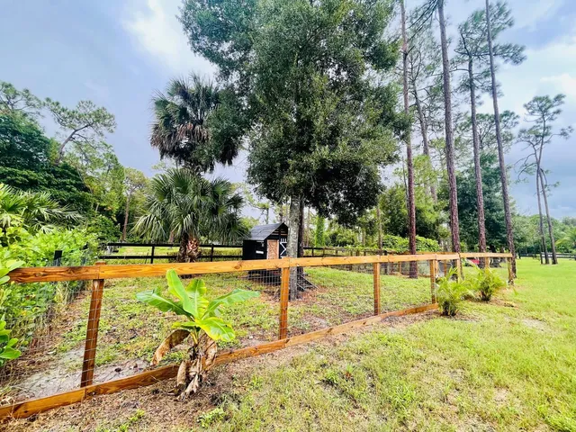 an empty room with a chandelier fan and window