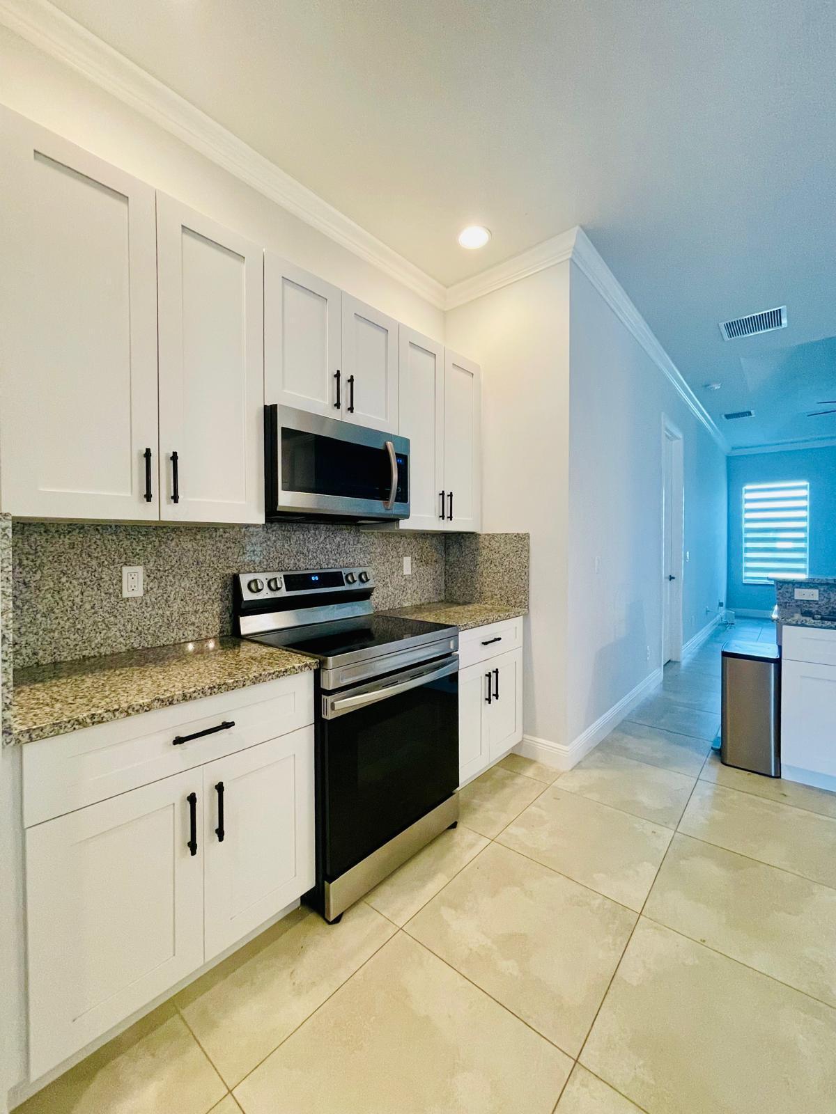 17225 78th Road North Loxahatchee, FL 33470 - Photo 9 of 93 a kitchen with stainless steel appliances granite countertop a stove a sink and a white cabinets