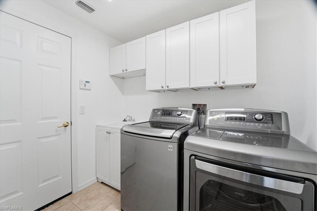 14439 Manchester Drive Naples, FL 34114 - Photo 21 of 47 a view of washer and dryer with kitchen in the background