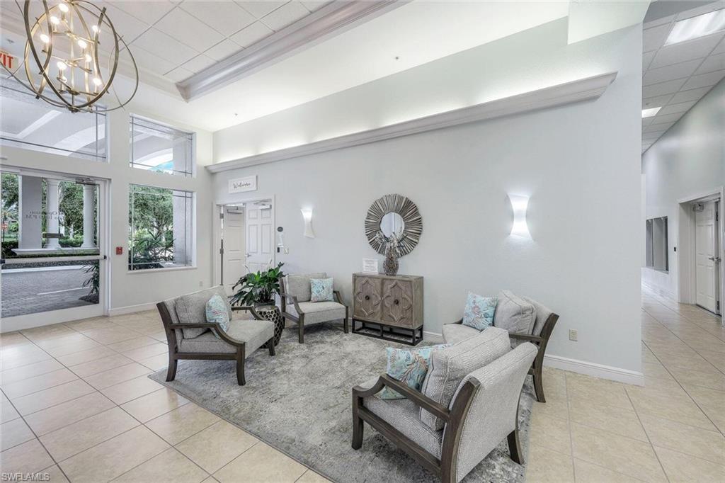 14439 Manchester Drive Naples, FL 34114 - Photo 23 of 47 a living room with furniture a clock and a large window