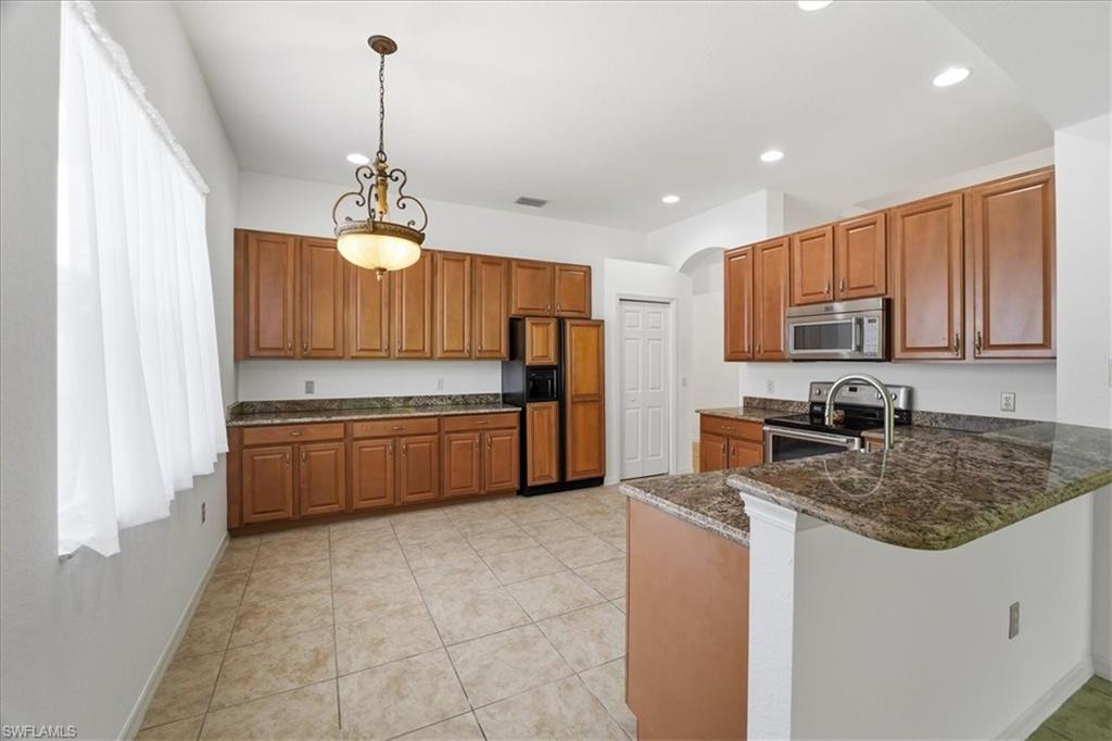 14439 Manchester Drive Naples, FL 34114 - Photo 4 of 47 a kitchen with stainless steel appliances granite countertop a stove sink and cabinets