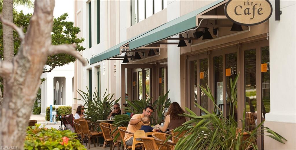 14439 Manchester Drive Naples, FL 34114 - Photo 45 of 47 a view of a house with potted plants and a bench in front of it