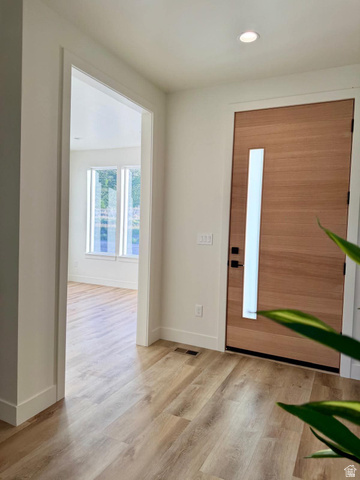 905 Settlement Canyon Road Tooele, UT 84074 - Photo 9 of 12 Entryway featuring contemporary wood-paneled door with vertical frosted glass insert, wood-finish flooring, and recessed ceiling lighting