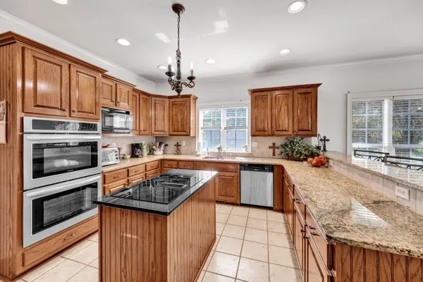 a kitchen with stainless steel appliances granite countertop a sink and a refrigerator