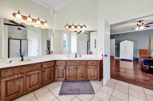 a spacious en suite bathroom with a sink mirror and a bath tub