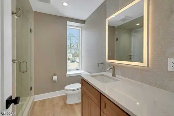 a bathroom with a granite countertop sink toilet and shower