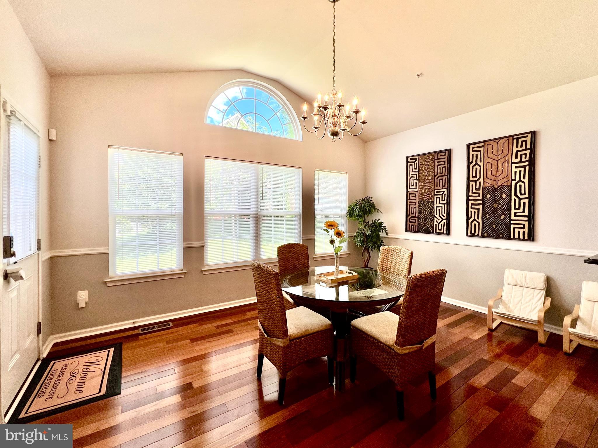 13501 Oaklands Manor Drive Laurel, MD 20708 - Photo 24 of 46 a view of a dining room with furniture a chandelier and wooden floor