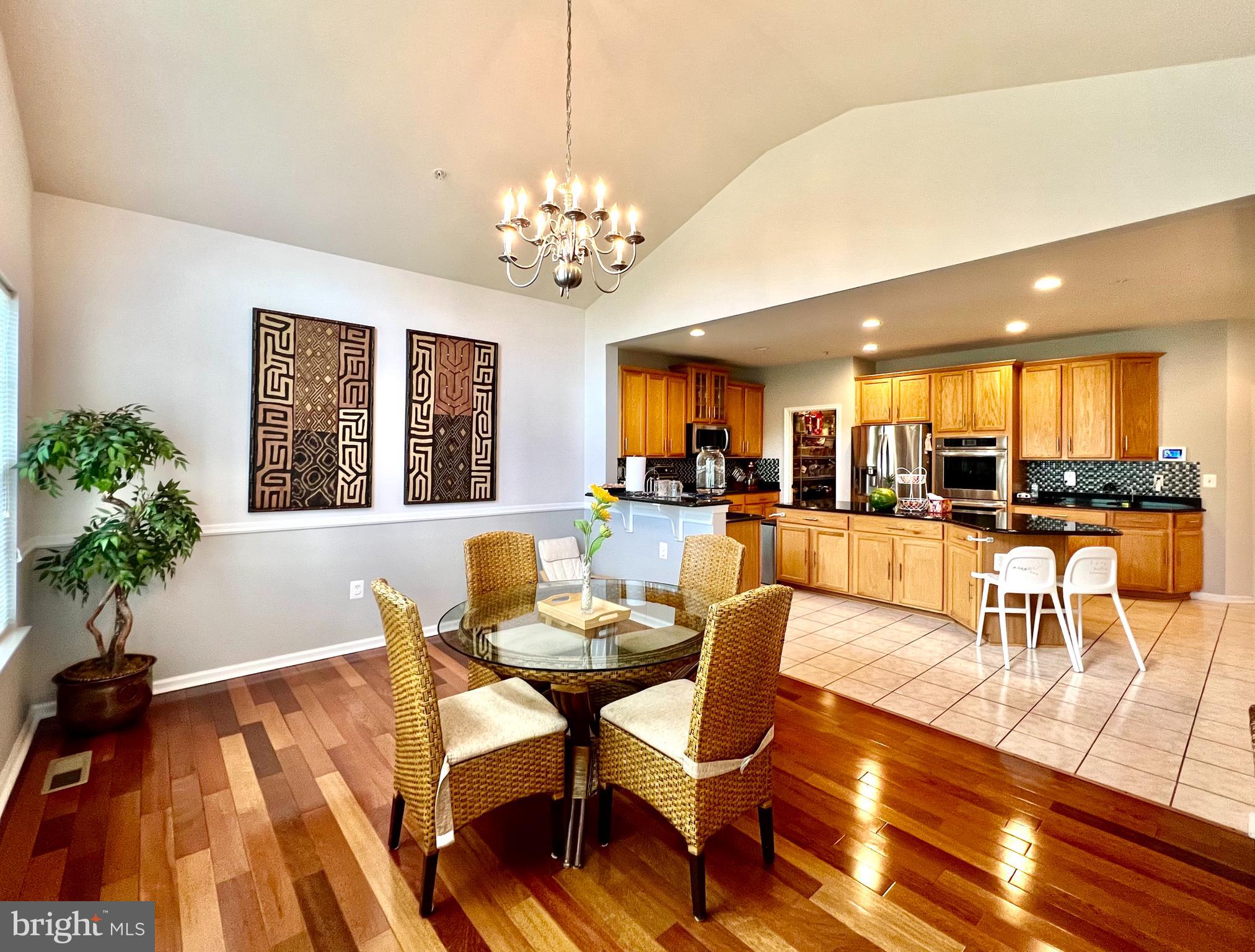 13501 Oaklands Manor Drive Laurel, MD 20708 - Photo 25 of 46 a view of a dining room and livingroom with furniture wooden floor a chandelier