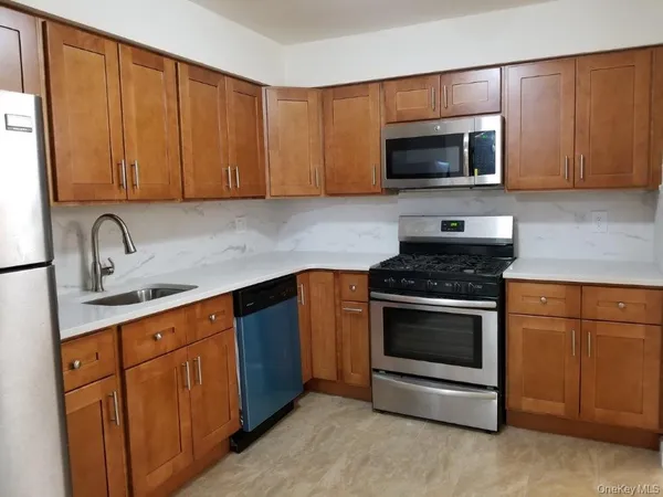 a kitchen with stainless steel appliances granite countertop a stove microwave and sink