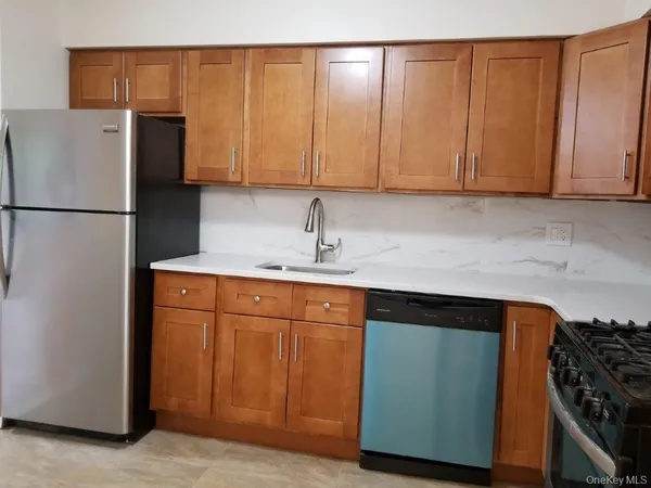 a kitchen with stainless steel appliances granite countertop a refrigerator a sink and cabinets