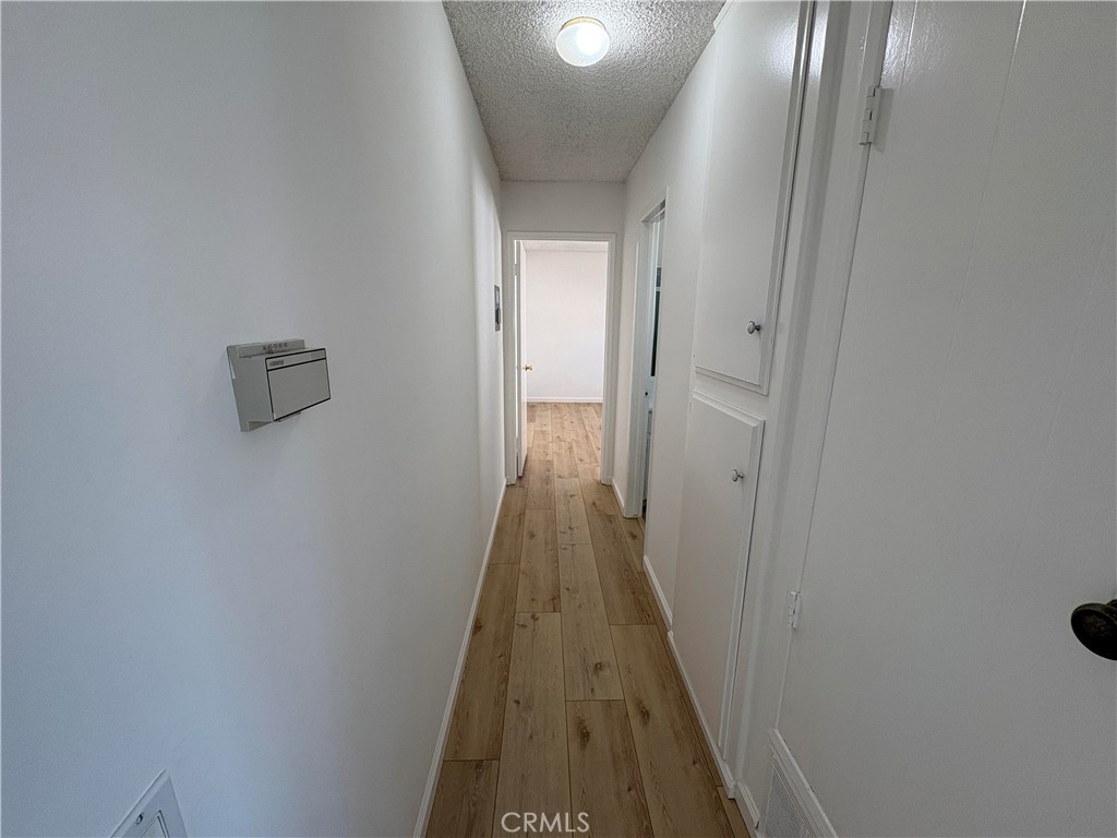 17061 Evergreen Circle, Unit D Huntington Beach, CA 92647 - Photo 7 of 18 a view of a hallway with wooden floor