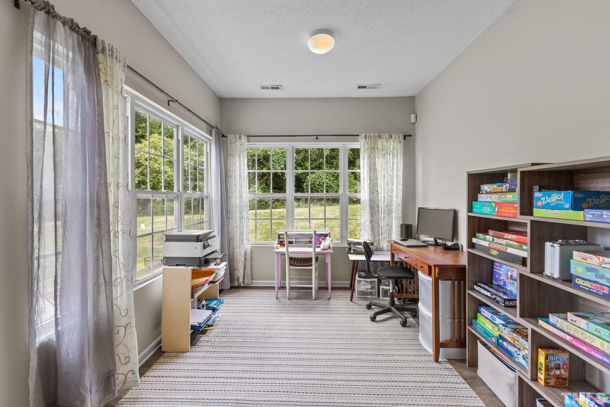 3366 Bridgeville Road Raleigh, NC 27610 - Photo 12 of 37 a view of a workspace with furniture and a book shelf