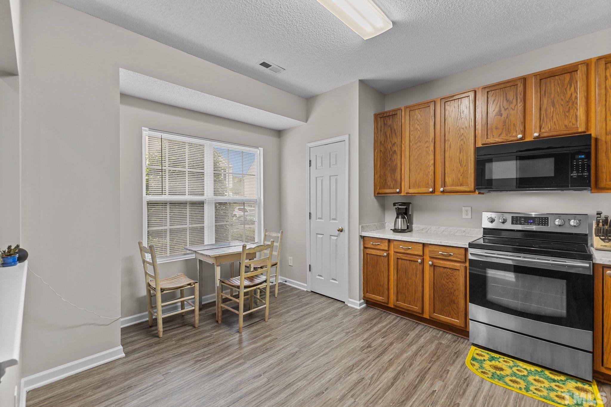 3366 Bridgeville Road Raleigh, NC 27610 - Photo 5 of 37 a kitchen with stainless steel appliances granite countertop wooden floors and stove top oven