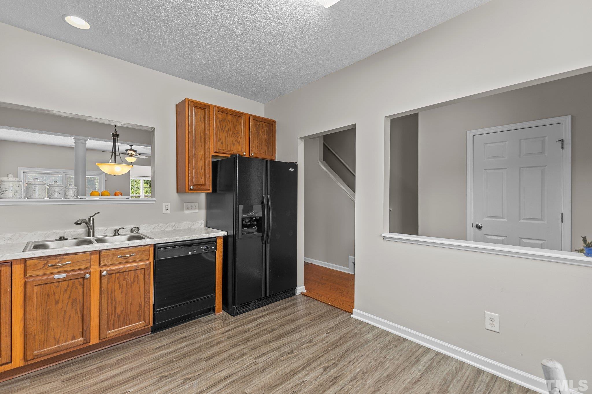 3366 Bridgeville Road Raleigh, NC 27610 - Photo 6 of 37 a kitchen with stainless steel appliances granite countertop a refrigerator a sink and wooden cabinets