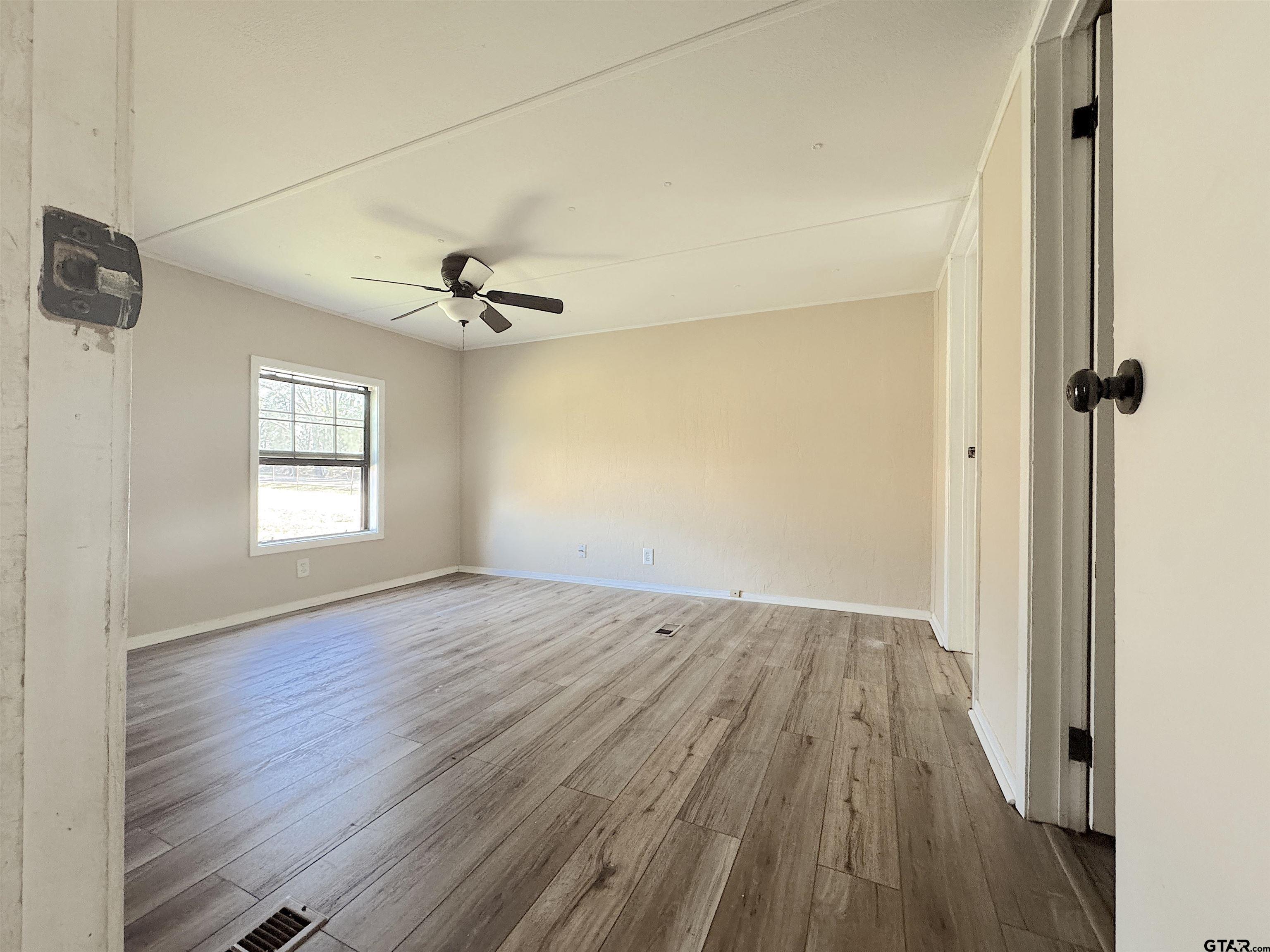 1391 San Saba Road Mount Vernon, TX 75457 - Photo 12 of 13 wooden floor in an empty room with a window