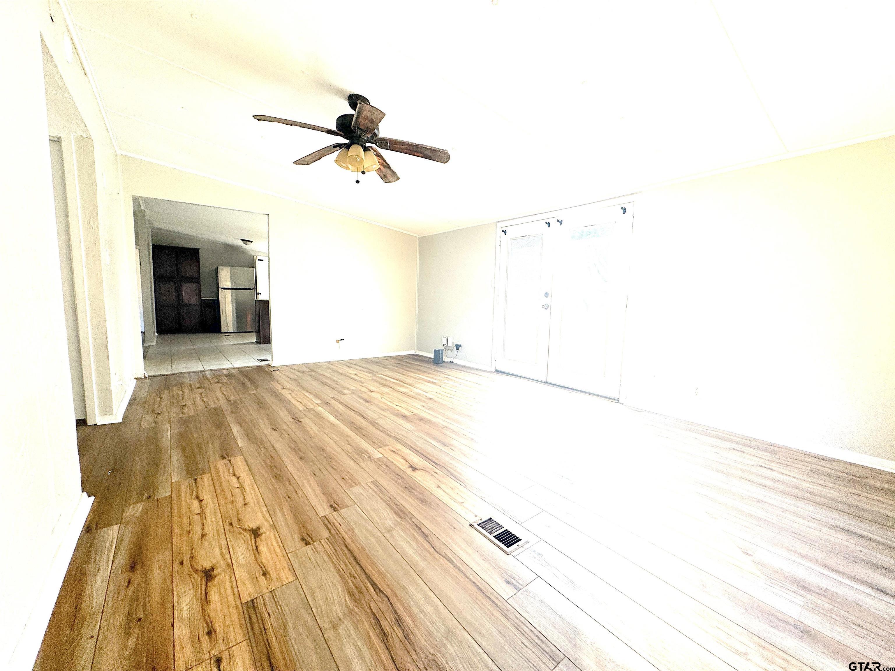 1391 San Saba Road Mount Vernon, TX 75457 - Photo 6 of 13 a view of a livingroom with wooden floor and a ceiling fan