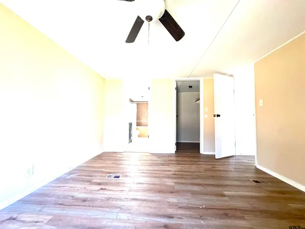 a view of empty room with wooden floor