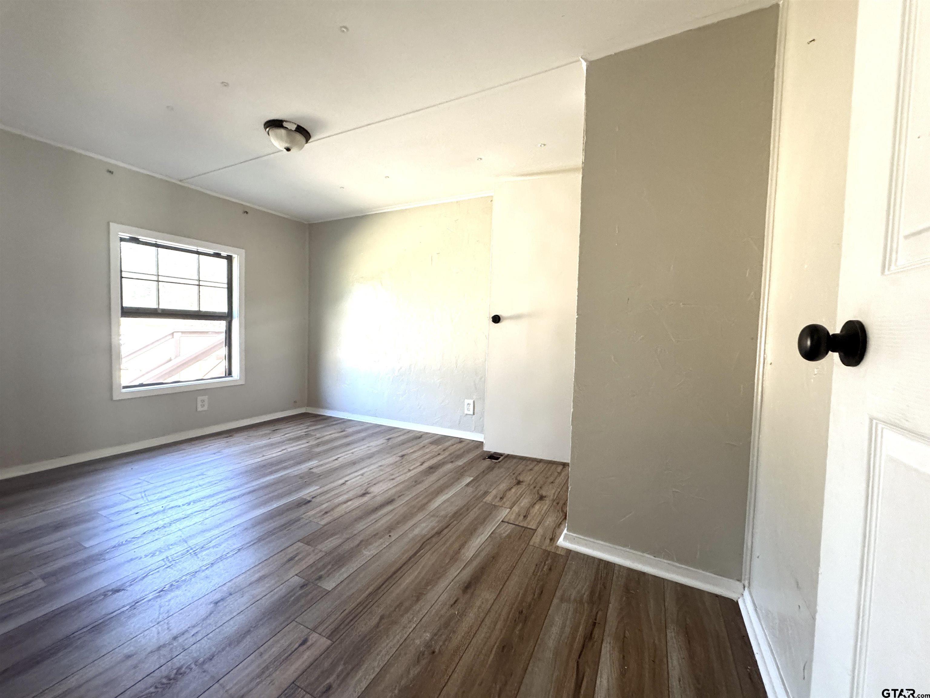 1391 San Saba Road Mount Vernon, TX 75457 - Photo 10 of 13 a view of an empty room with wooden floor and a window