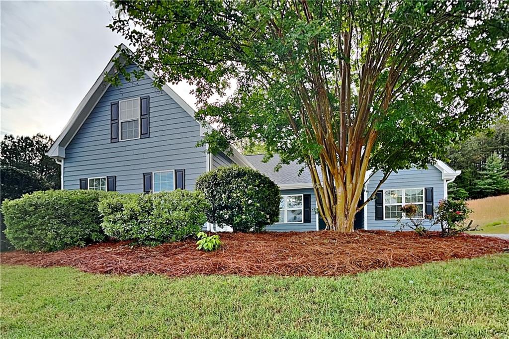 6345 Aarons Way Flowery Branch, GA 30542 - Photo 1 of 19 a front view of a house with a garden