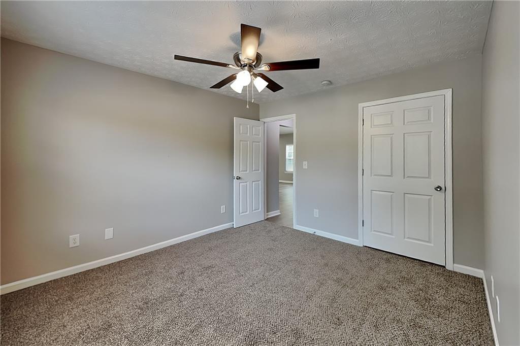 6345 Aarons Way Flowery Branch, GA 30542 - Photo 11 of 19 an empty room with closet and a chandelier fan
