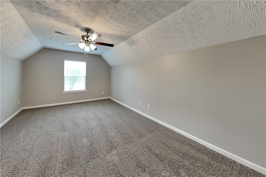 6345 Aarons Way Flowery Branch, GA 30542 - Photo 15 of 19 an empty room with a chandelier fan and windows