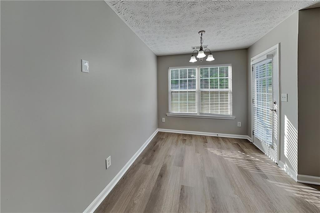 6345 Aarons Way Flowery Branch, GA 30542 - Photo 6 of 19 wooden floor in an empty room with a window